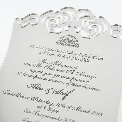 A luxurious silver mirror acrylic wedding invitation with a distinctive curved, shield-like silhouette. The top and bottom edges feature intricate laser-cut scrollwork that creates a decorative, open-work lace effect.