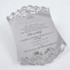 A luxurious silver mirror acrylic wedding invitation with a distinctive curved, shield-like silhouette. The top and bottom edges feature intricate laser-cut scrollwork that creates a decorative, open-work lace effect.
