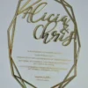 A transparent acrylic wedding invitation with a striking laser-cut geometric gold border. The invitation is hexagonal in its overall silhouette, featuring sharp, intersecting gold lines that create a crystalline frame.
