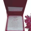 An open, square magenta silk invitation box displayed alongside its contents. The interior of the lid features a vertical magenta band on the left with a gold laser-cut floral pattern and a white panel on the right with elegant pink script. The main base of the box holds a matching white invitation card with magenta borders. A stem of vibrant pink gladiolus flowers lies to the right, and the entire set is presented on a clean white background.c