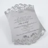 A luxuriAous silver mirror acrylic wedding invitation with a distinctive curved, shield-like silhouette. The top and bottom edges feature intricate laser-cut scrollwork that creates a decorative, open-work lace effect.