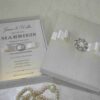 Ivory wedding invitation box suite featuring foil stamp details on pearl shimmery cardstock with a silk card holder.