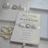 Handmade silk wedding invitation box adorned with a crystal rhinestone and pearl brooch for luxury wedding stationery.