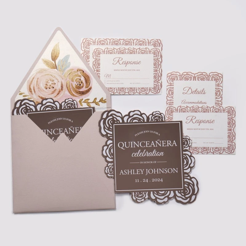 An elegant Quinceañera invitation suite featuring a dusty rose and rose gold color palette, laid out on a light gray background. The set includes several coordinated pieces: Main Invitation: A square, chocolate-brown card with a decorative rose gold laser-cut floral border made of rose patterns. The white and rose gold text reads, "PLEASE JOIN US FOR A QUINCEAÑERA celebration IN HONOR OF ASHLEY JOHNSON" with the date "11.24.2024." Enclosure Cards: Three white cards featuring a matching rose gold floral pattern around the edges. These include two "Response" (RSVP) cards and one "Details" card for accommodations. Envelope: A dusty rose envelope is shown open, revealing a luxurious floral liner featuring large painted roses in shades of cream, pink, and gold with gold leaf accents. A second invitation card is partially tucked inside.