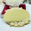This image showcases a luxurious gold mirror acrylic wedding invitation with a unique, scalloped circular shape. It is positioned in front of an open white box lined with rich burgundy satin, which holds a large, white Box.