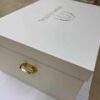 Luxury bridal lehenga box crafted from 7mm MDF featuring a white pearl shimmer finish, custom gold foil branding for a fashion designer, and premium side handles for couture trousseau packaging.