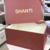 A high-end bridal lehenga trunk box made of a thick orange MDF frame with a smooth matte finish, featuring a custom gold foil-pressed logo on the lid and a sturdy antique brass handle on the side for professional fashion packaging.