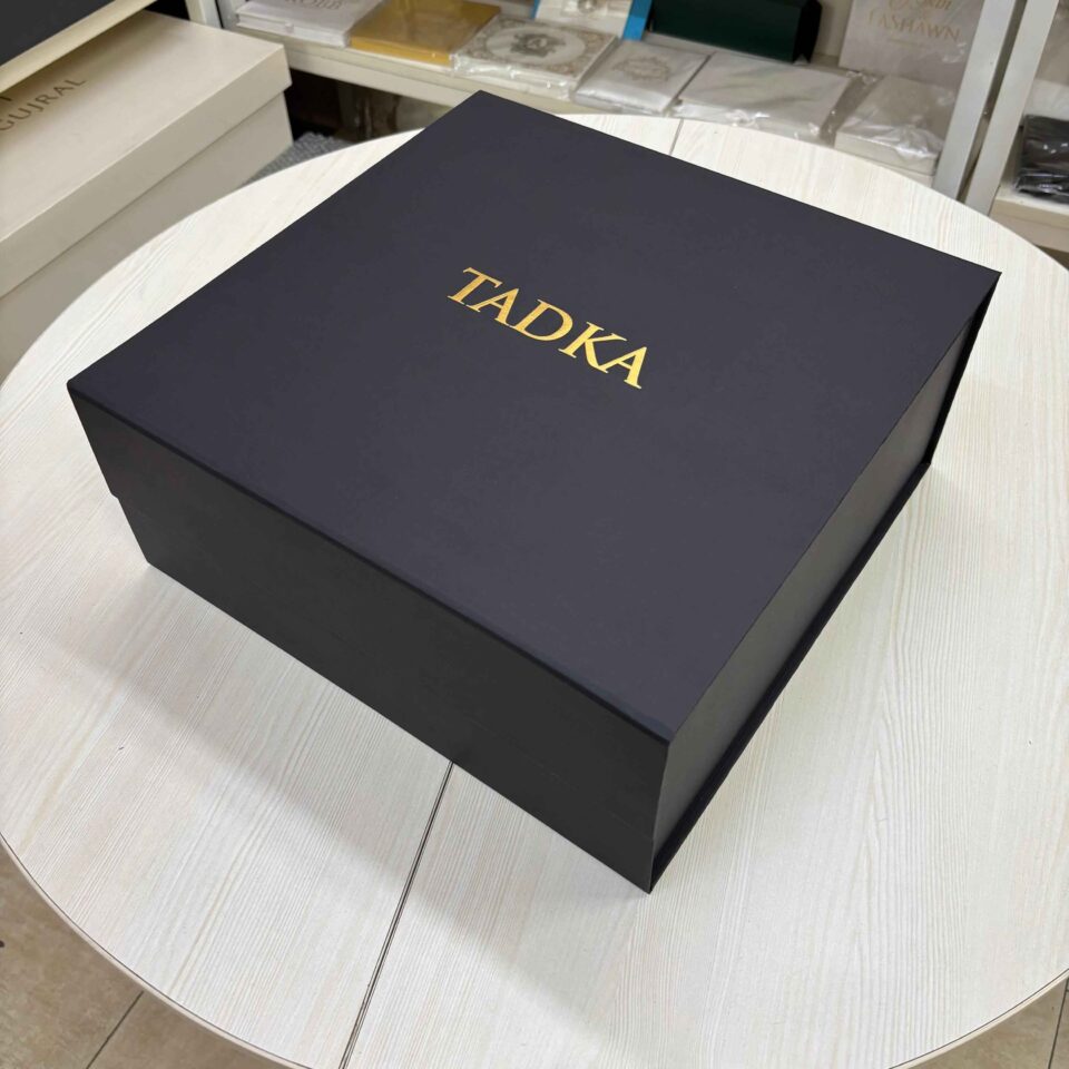 Matte black collapsible rigid box with gold foil logo branding.