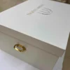 White Shimmer Top Bottom Bridal Lehenga Box with Gold Foil Logo Printing. Box is crafted from a rigid MDF core & Equipped with premium gold handles.