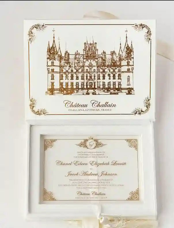 Ivory velvet wedding invitation box with a gold foil venue illustration and a clear acrylic invitation with gold printed details.
