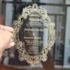 Clear acrylic wedding invitation with ornate gold baroque scrollwork frame and engraved couple's names