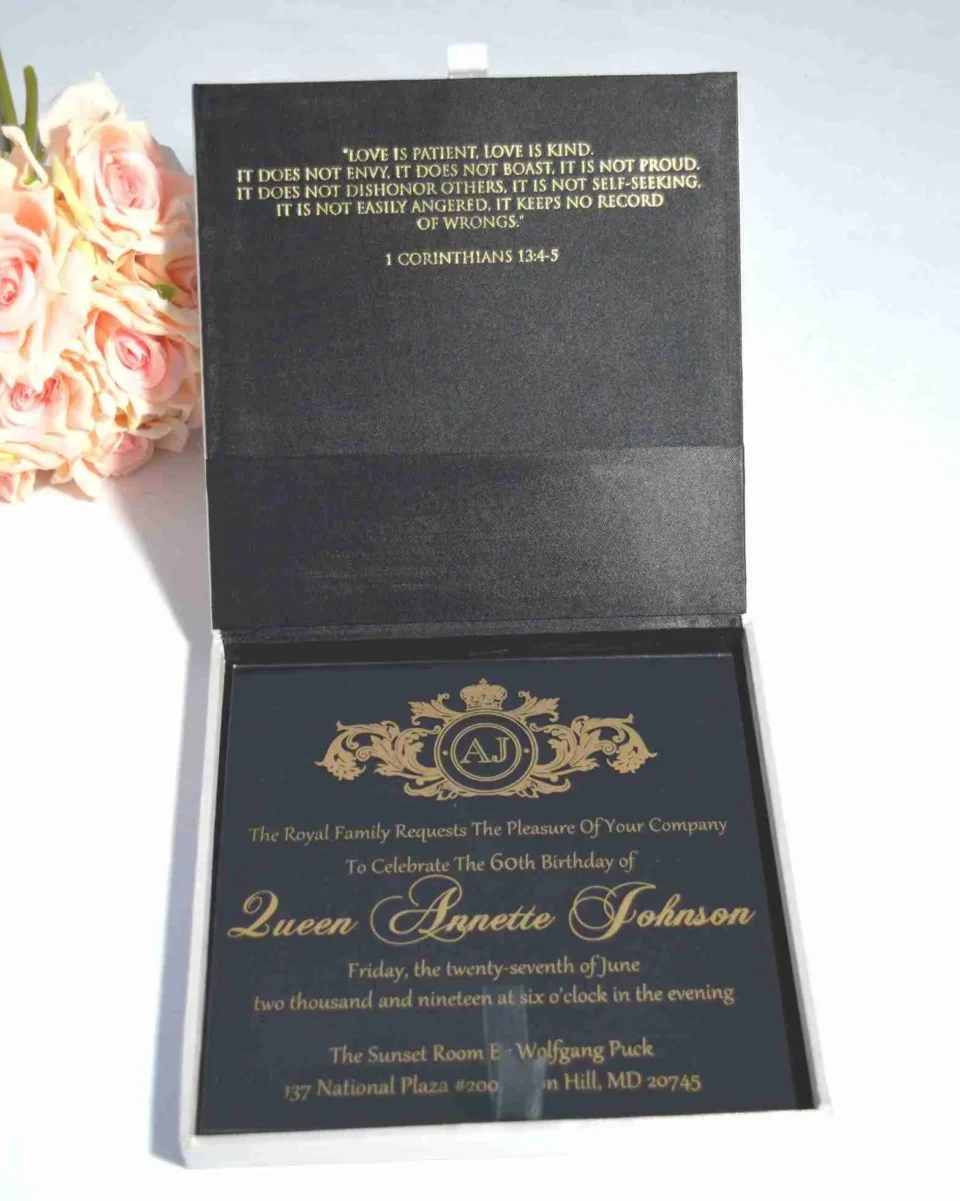 Open satin wedding invitation box showing gold foil Bible verse and acrylic invitation card inside