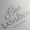 Close-up of gold foil-stamped names and wedding date on ivory satin invitation box cover