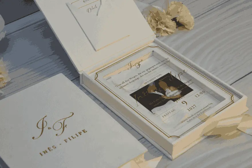 Open ivory velvet invitation box with the lid raised, a clear acrylic invitation in gold foil over a couple’s photo, and a pocket for enclosure cards in the lid.